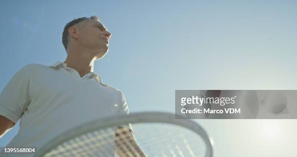 ein reifer mann, der auf einem außenplatz eine partie tennis spielt - tennis court and low angle stock-fotos und bilder