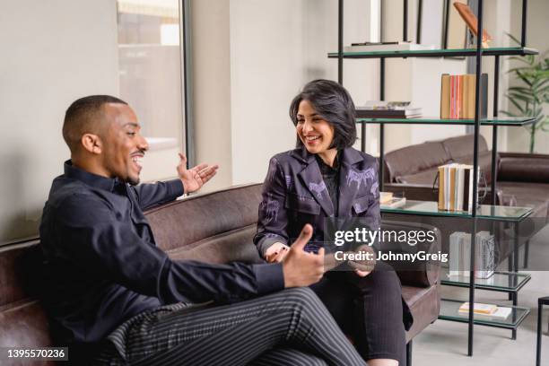 fröhliche saudische geschäftspartner entspannen sich und unterhalten sich - kompatibilität stock-fotos und bilder