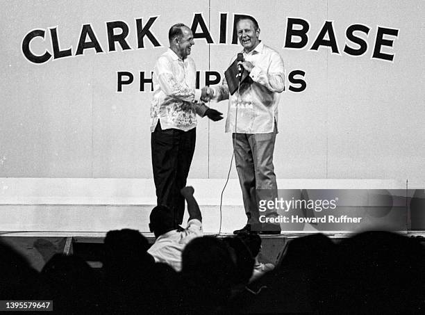Canadian-born American media personality Art Linkletter is awarded a plaque by an unidentified man during a performance as part of a USO tour at...
