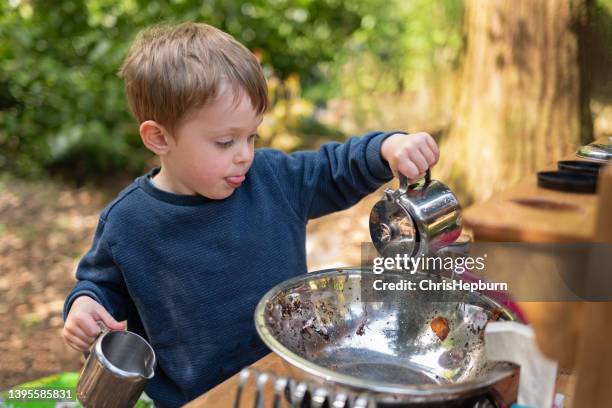 young boy playing outdoors with a mud kitchen - toddler stock pictures, royalty-free photos & images