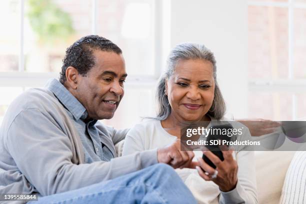 husband and wife sit on the couch - visit us stock pictures, royalty-free photos & images