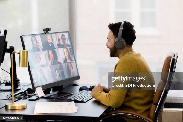 remote employee uses his headphones to attend a video conference - medium group of people stock pictures, royalty-free photos & images