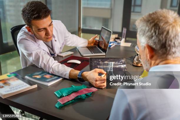 doctors in rehabilitation hospital explaining spine injury to patient - x ray pelvis stock pictures, royalty-free photos & images