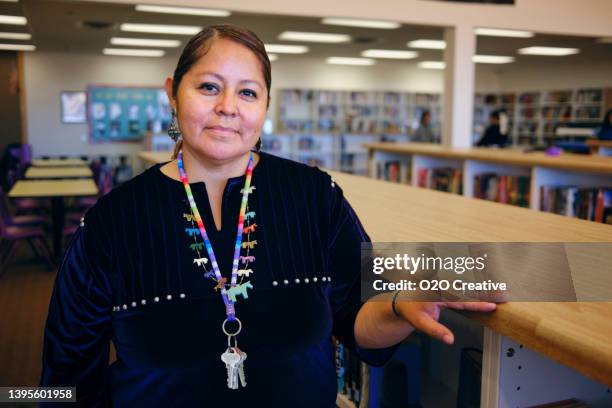 high school teacher in a library - inheemse bevolking stockfoto's en -beelden