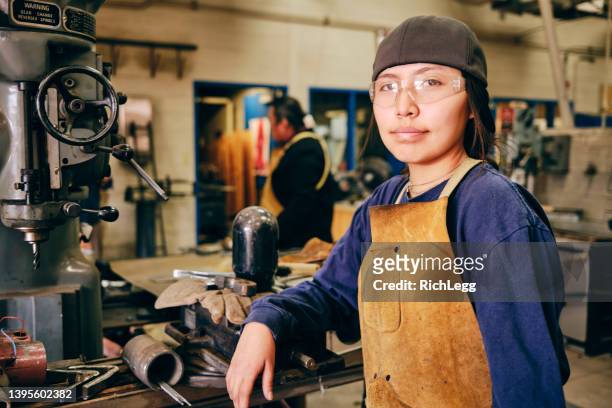 teenage worker in an automive workshop - minority groups professional stock pictures, royalty-free photos & images