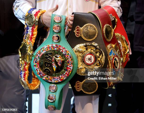 Canelo Alvarez holds various belts as he poses during a news conference at the KA Theatre at MGM Grand Hotel & Casino on May 05, 2022 in Las Vegas,...