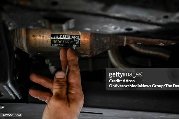 Steve Horvath, owner of Jeno's Auto Service Inc., places a sticker on the catalytic converter of a Toyota Tacoma on Thursday, May 5, 2022. Horvath...