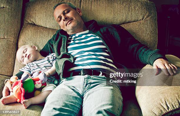 Boy with grandfather sleeping on sofa