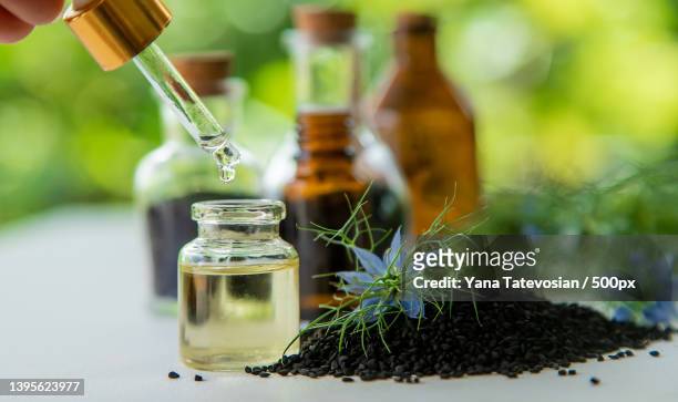 black cumin oil in a bottle selective focus - nigella stock pictures, royalty-free photos & images