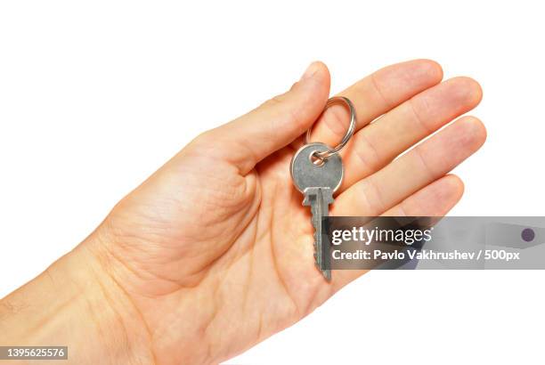silver key in a hand isolated on white - key ring isolated stockfoto's en -beelden