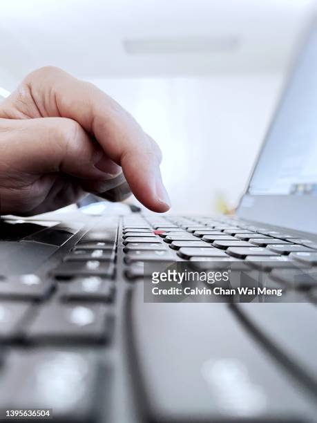 adult hand typing on keyboard of notebook - data breach fotografías e imágenes de stock