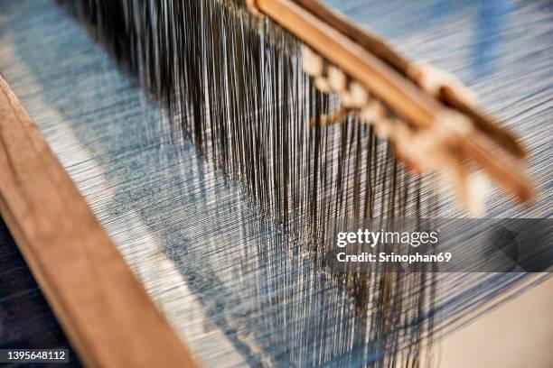 traditional silk weaving can be seen in the countryside of thailand. selective focus - schussfaden stock-fotos und bilder