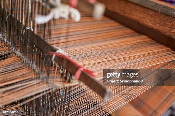 traditional silk weaving can be seen in the countryside of thailand. selective focus - webstuhl stock-fotos und bilder