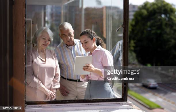 manager at a nursing home talking to a senior couple about the facilities - vulnerability management stock pictures, royalty-free photos & images
