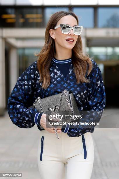 Influencer Alexandra Lapp wearing a dark blue flight mode silk sweater with all over monogram print by Louis Vuitton, a cream colored flight mode...