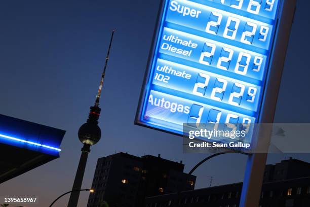 Sign displays prices for diesel and gasoline at a petrol station as the iconic broadcast tower at Alexanderplatz stands behind on May 05, 2022 in...