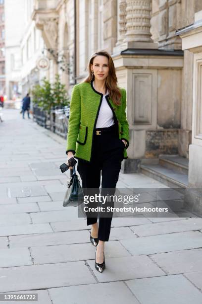 Influencer Alexandra Lapp wearing a light green vintage jacket by Saint Laurent, a white tank top by Mango, black pants by Max Mara, a dark green...