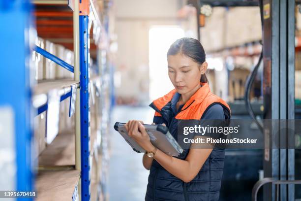 warehouse worker holding digital tablet checking goods and supplies on shelves with goods background in warehouse. - operational technology stock pictures, royalty-free photos & images