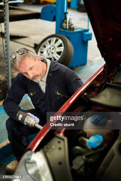 mechanic removing a wheel - air gun stock pictures, royalty-free photos & images