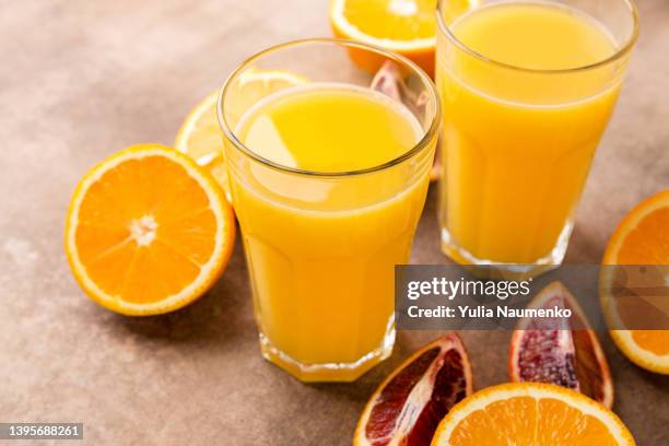 fresh orange juice with oranges. two glasses of freshly squeezed juice. - orange juice stock pictures, royalty-free photos & images