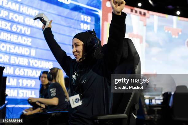 cheerful female gamer won online video game while playing at esports arena - esports foto e immagini stock