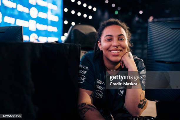 smiling gamer with hand on chin in esports league - e sport stock pictures, royalty-free photos & images