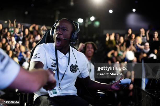 male gamer shaking hand after winning esports competition - ゲーマー ストックフォトと画像