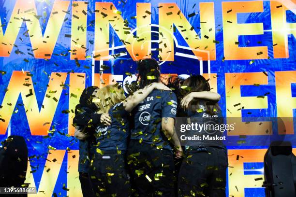 female gaming champions celebrating tournament win while huddling amidst confetti at esports arena - transgender athlete stock pictures, royalty-free photos & images