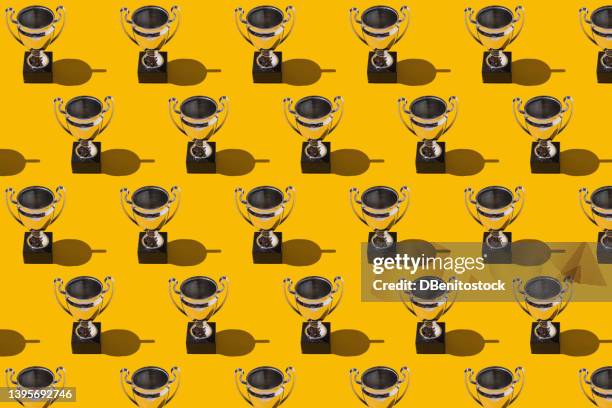 trophy cups winner champion cups pattern with hard shadow on yellow background. concept of victory, winner, european champion, world champion, soccer and sport. - pride awards ceremony stock pictures, royalty-free photos & images