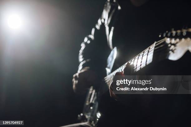 close-up of a guitar, a man gatarist plays rock on a musical instrument or composes music - black guitarist stock pictures, royalty-free photos & images