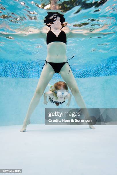 mother with child in swimming pool - breitbeinig stehen stock-fotos und bilder