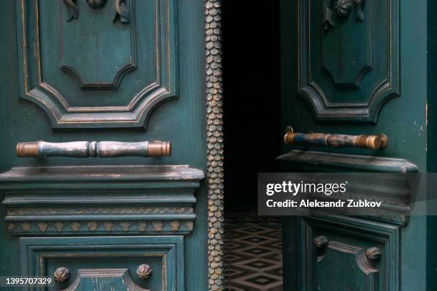 an old worn-out open front door, recently painted, with a bronze or metal wrought iron handle as a background. door handle close-up. copy space. - ornate key stock pictures, royalty-free photos & images