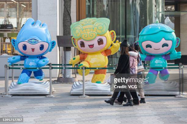Pedestrians walk by statues of mascots for the 19th Asian Games Hangzhou 2022 on January 11, 2021 in Hangzhou, Zhejiang Province of China.
