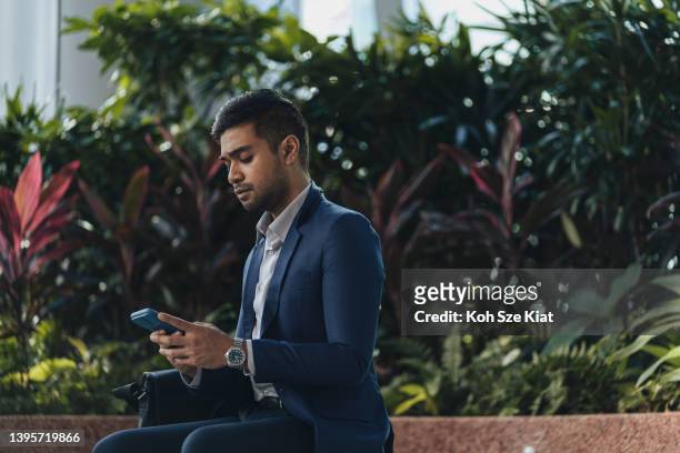 affari di successo - uomo indiano in giacca e cravatta messaggi di testo - indian economy business and finance foto e immagini stock