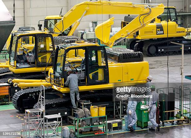 Employees assemble Komatsu Ltd. Excavators on the production line of the company's plant in Hirakata City, Osaka, Japan, on Thursday, Feb. 23, 2012....
