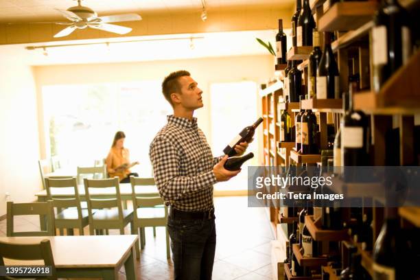 man choosing wine in shop - choosing wine stock pictures, royalty-free photos & images