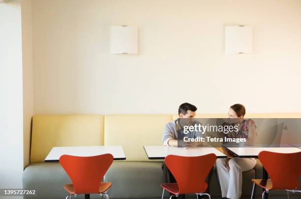 coworkers having discussion in office cafeteria - workplace canteen lunch stock pictures, royalty-free photos & images