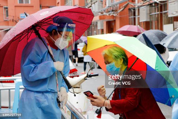 Residents queue up for COVID-19 nucleic acid tests at a residential community during a rainfall on May 6, 2022 in Beijing, China.