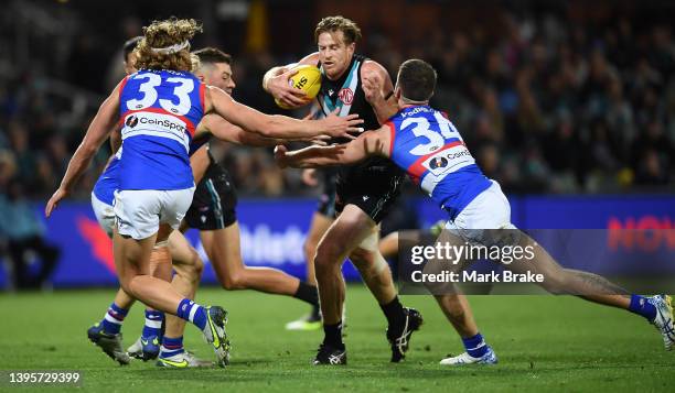 Tom Jonas of Port Adelaide tackled by Bailey Dale and Josh Dunkley of the Bulldogs during the round eight AFL match between the Port Adelaide Power...