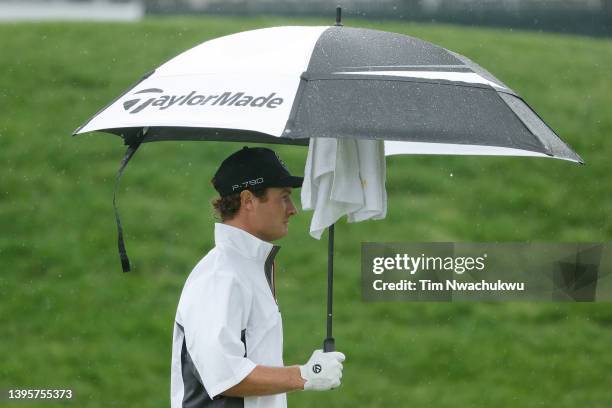 Drew Nesbitt of Canada walks off the 17th tee under an umbrella during the second round of the Wells Fargo Championship at TPC Potomac Clubhouse on...