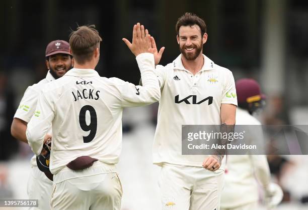 Jordan Clark of Surrey celebrates taking the wicket of Lewis McManus of Northamptonshire with teammates during Day Two of the LV= Insurance County...