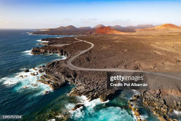 aerial view of los hervideros with red mountain volcano (montaña bermeja volcan) in the background - lanzarote, canary islands, spain - lanzarote fotografías e imágenes de stock