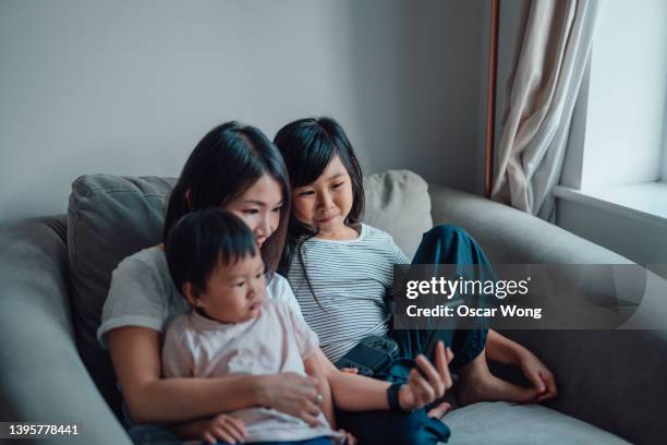 family having video call on smart phone - chinese family taking photo at home stock pictures, royalty-free photos & images