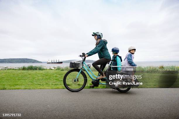 bike ride on cargo e-bike carries the whole family - women road cycling stock pictures, royalty-free photos & images