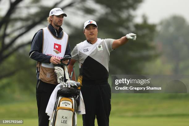 Kyoung-Hoon Lee of South Korea talks with his caddie Daniel Parratt before hitting an approach shot on the 15th hole during the second round of the...