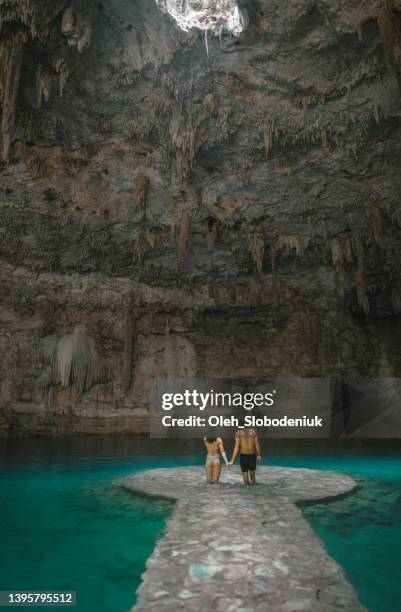 couple standing in cenote in yucatan, mexico - cenote stock pictures, royalty-free photos & images