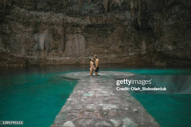 casal em cenote em yucatan, méxico - poço - fotografias e filmes do acervo