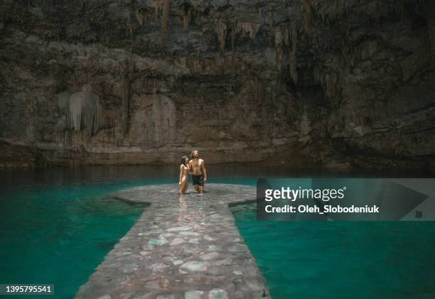 couple standing  in cenote in yucatan, mexico - cenote stock pictures, royalty-free photos & images
