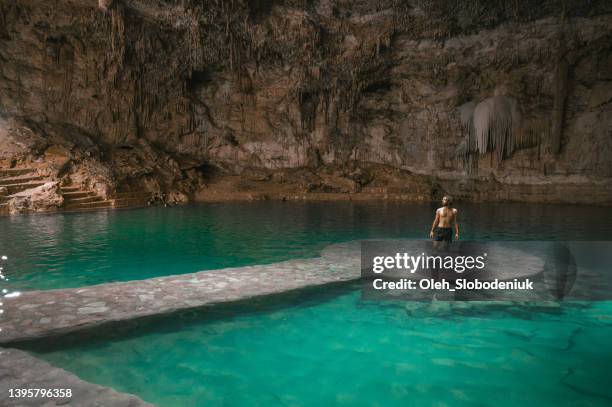 man standing  in cenote in yucatan, mexico - tulum mexico stockfoto's en -beelden