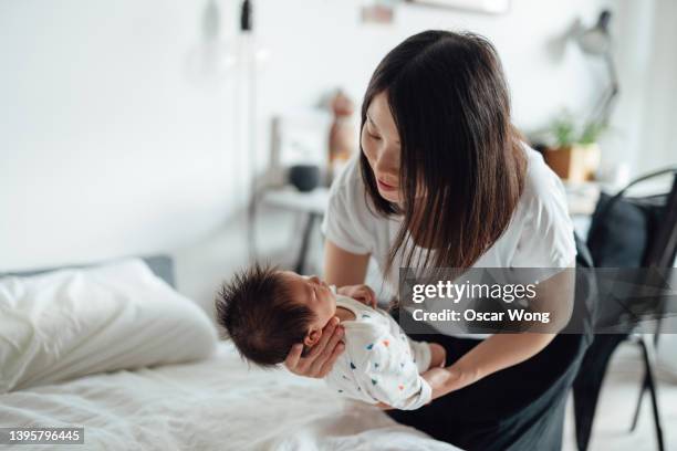 mother taking care of her newborn baby - babyhood stock pictures, royalty-free photos & images